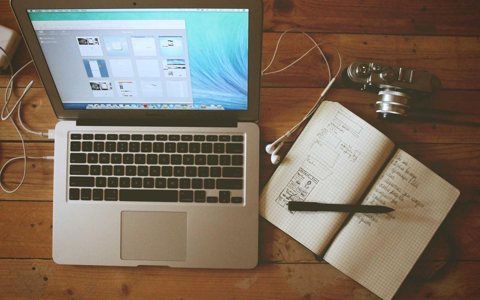 A laptop showing the EeziCalc workspace alongside a notebook with figures